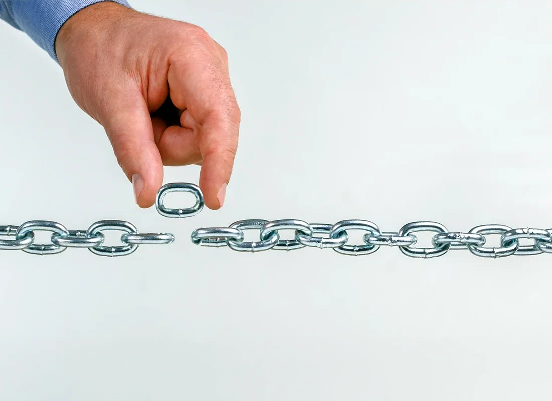 man's hand holding a link from a chain